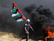 فلسطينيّ غزيّ يرفع الأعلام الفلسطينيّة 