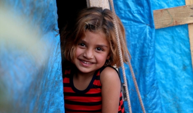 بسمة طفلة سورية في مخيم للاجئين