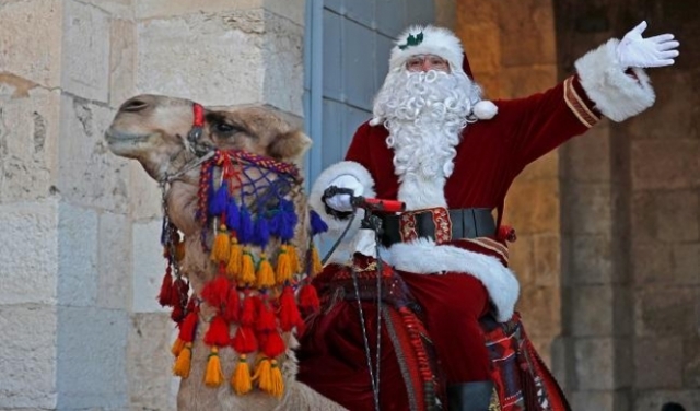 بابا نويل يجول حارات القدس على الجمل