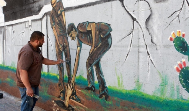 فنان غزّيٌ يرسم جدارية لأسرى نفق الحرية