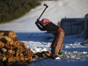 امرأة مغربية تقطع الحطب في قرية تيمحضيت الجبلية النائية