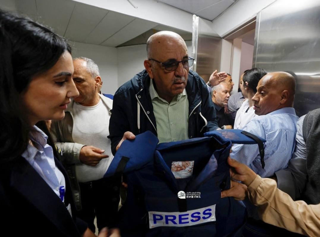 وليد العمري يحمل درع الصحافة الذي كانت ترتديه الصحافية شيرين أبو عاقلة لحظة